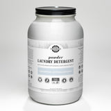A glass jar holds Rustic Strength unscented, hypoallergenic powder laundry detergent for 144 loads, featuring earth-derived minerals.