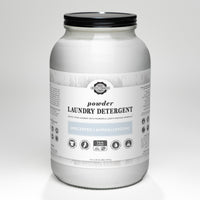 A glass jar holds Rustic Strength unscented, hypoallergenic powder laundry detergent for 144 loads, featuring earth-derived minerals.