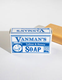 Close-up presents a box of Vanman's Tallow & Honey Soap, beside a loose bar of the rustic bath product.
