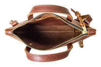 A view from above showcases the open, spacious interior of a brown leather tote bag with a zipper closure and carrying handles.
