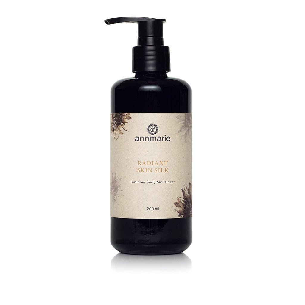 Annmarie Radiant Skin Silk Luxurious Body Moisturizer sits elegantly in a black pump bottle.

