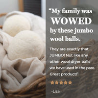 Two jumbo wool dryer balls sit nestled in a linen cloth inside a woven basket, promoting an eco-friendly laundry solution.
