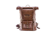 The stylish, handcrafted brown leather backpack features a roll-top closure, front pocket, and adjustable straps.

