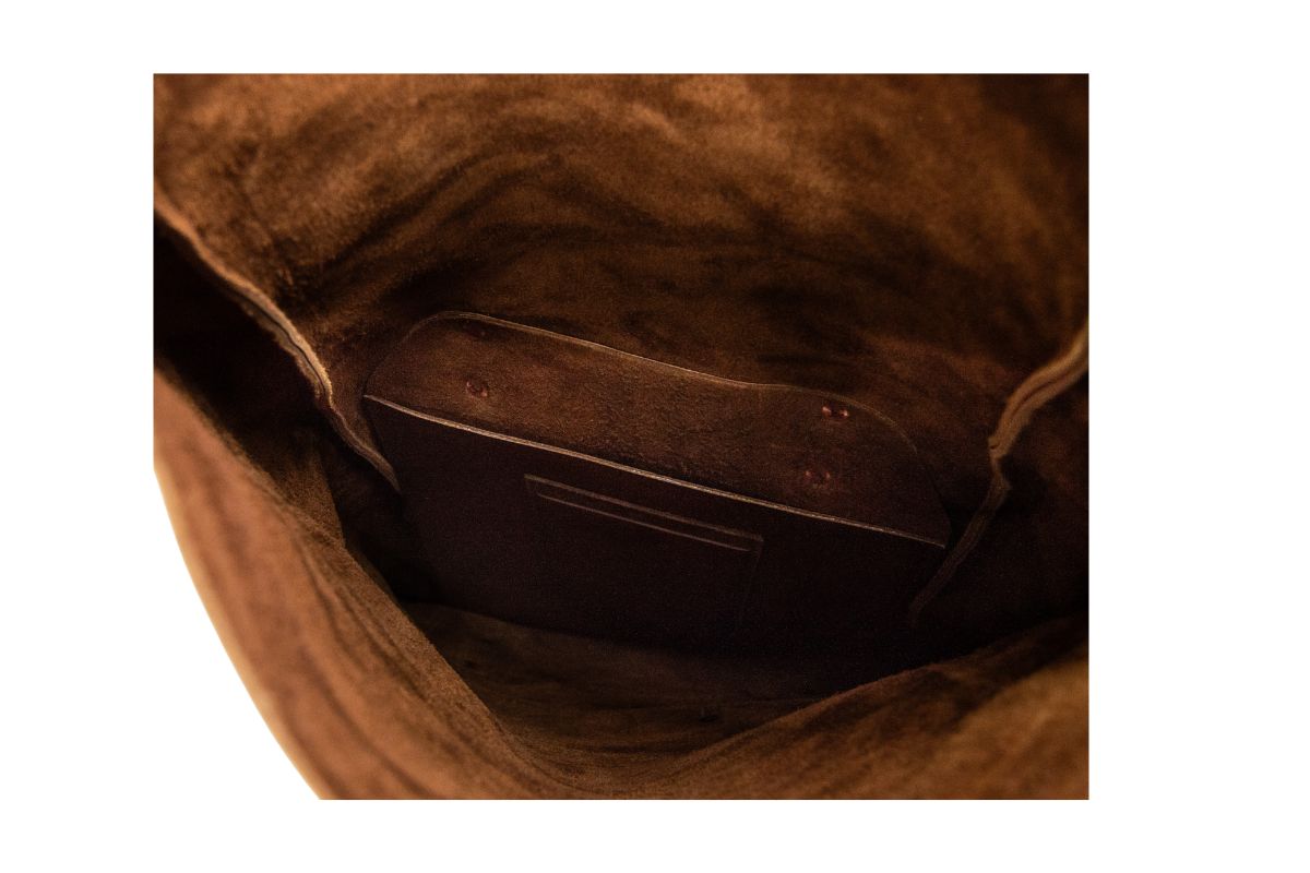View shows the interior of a soft brown leather bucket bag with a convenient pocket.

