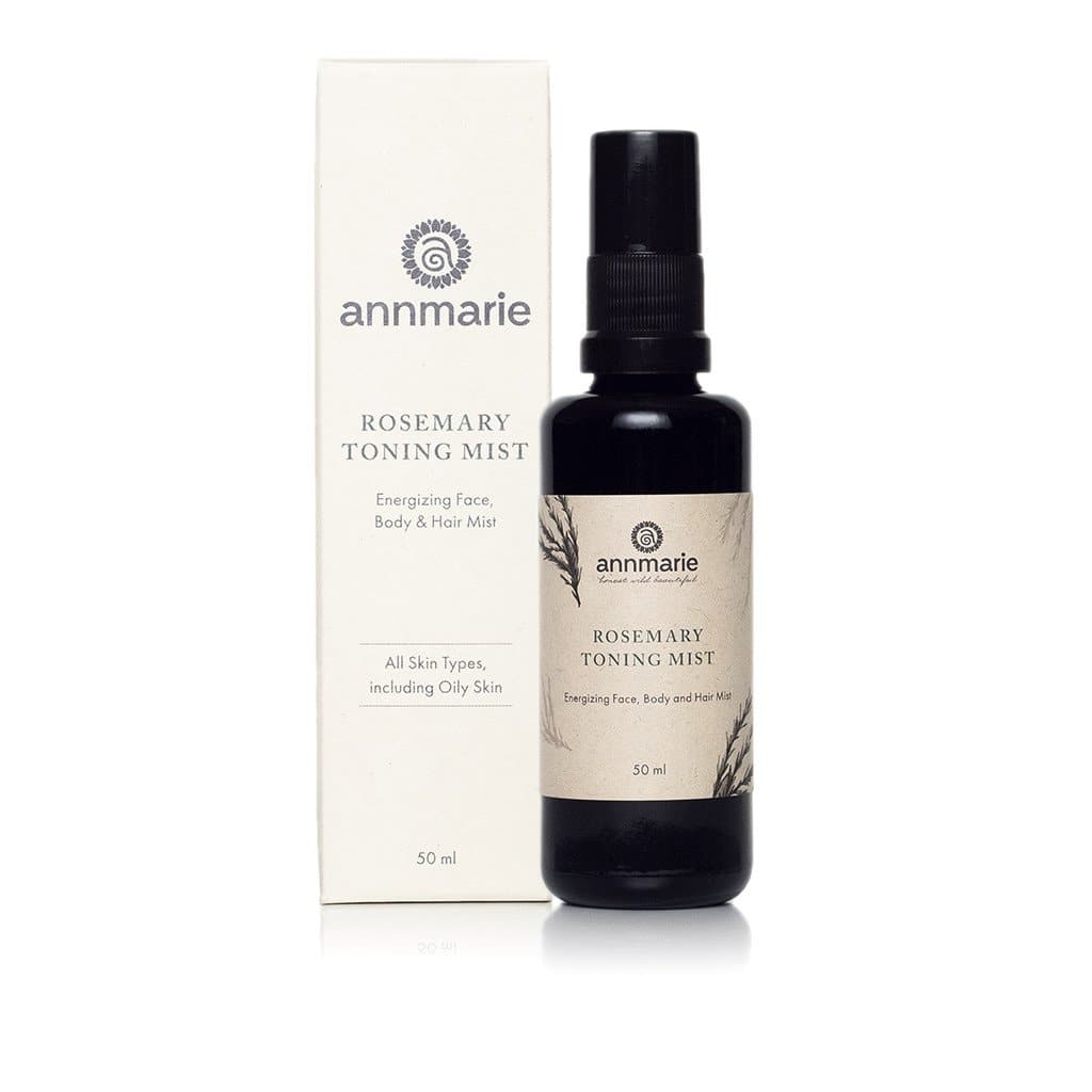 Annmarie's Rosemary Toning Mist for face, body, and hair sits beside its product box, advertising suitability for all skin types including oily skin.
