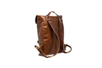 A stylish brown leather backpack displays its adjustable straps and brass buckles.
