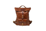 A vintage-style leather backpack with brass buckles sits against a white backdrop.
