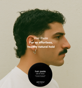 A man models a stylish hairstyle using Jack Henry hair paste for a light hold and natural finish.