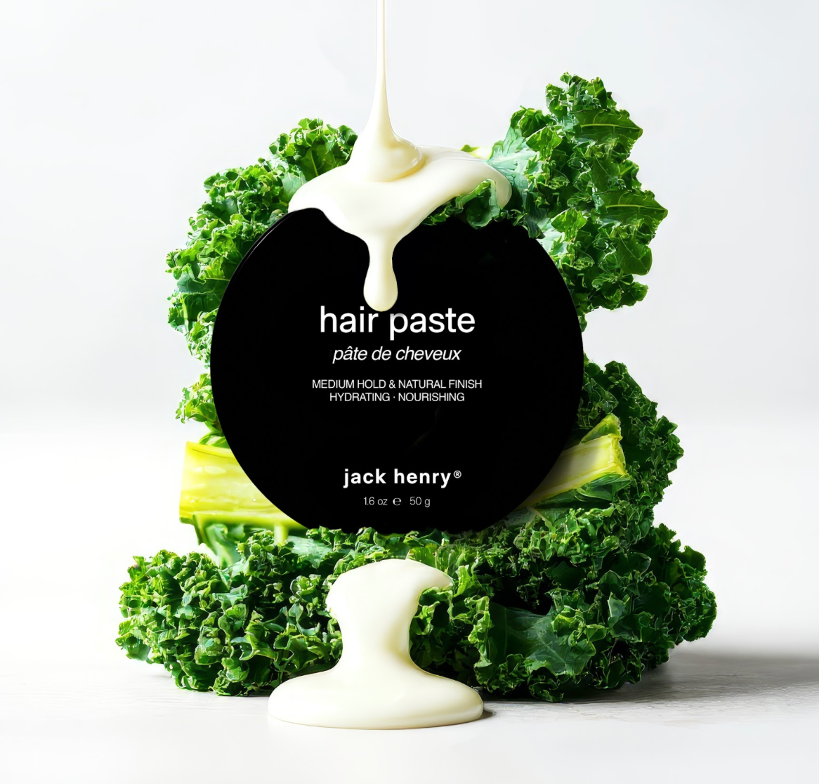 Creamy Jack Henry hair paste drips onto kale arranged around the product label.

