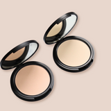 Two open compacts display light beige face powder with mirrors inside black cases.
