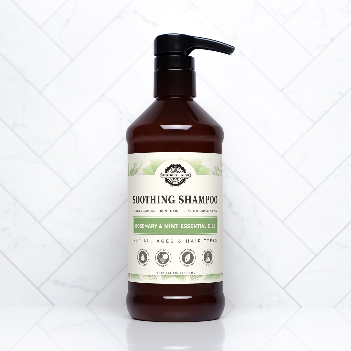A bottle of Rustic Strength Soothing Shampoo with rosemary and mint essential oils sits against a white tile background.