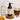 Showcases Rustic Strength's milk and honey soothing shampoo displayed with a jar of honey, honeycomb, and a pitcher of milk, promoting natural hair care.

