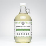 Rustic Strength's rosemary mint shampoo, in a glass jug, promises gentle cleansing with plant-derived ingredients suitable for all ages and hair types.