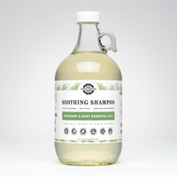 Rustic Strength's rosemary mint shampoo, in a glass jug, promises gentle cleansing with plant-derived ingredients suitable for all ages and hair types.