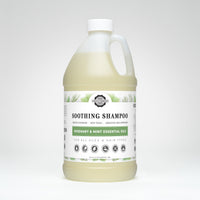 Display shows a bulk-sized bottle of Rustic Strength Soothing Shampoo with rosemary and mint essential oils, formulated for gentle cleansing and suitable for all ages and hair types.