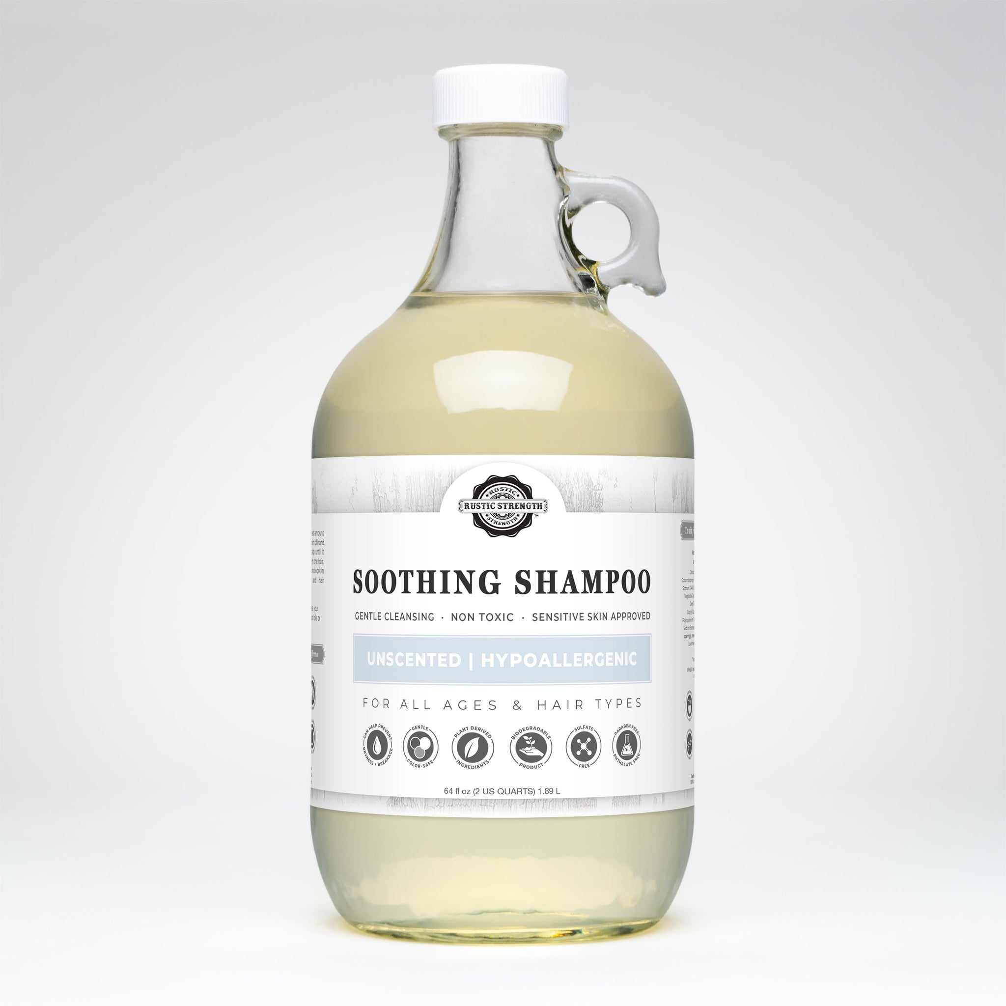 A glass jug displays Rustic Strength Soothing Shampoo, highlighting its unscented, hypoallergenic, and plant-derived formula.