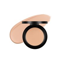 Compact powder rests beside a swatch of matching foundation, showcasing a perfect skin tone makeup set.
