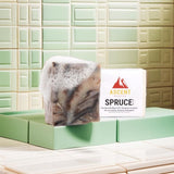 Ascent Spruce soap bar lathers with foam, promoting its natural and therapeutic essential oils.
