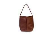 A brown leather bucket bag with a handle sits upright against a white background.
