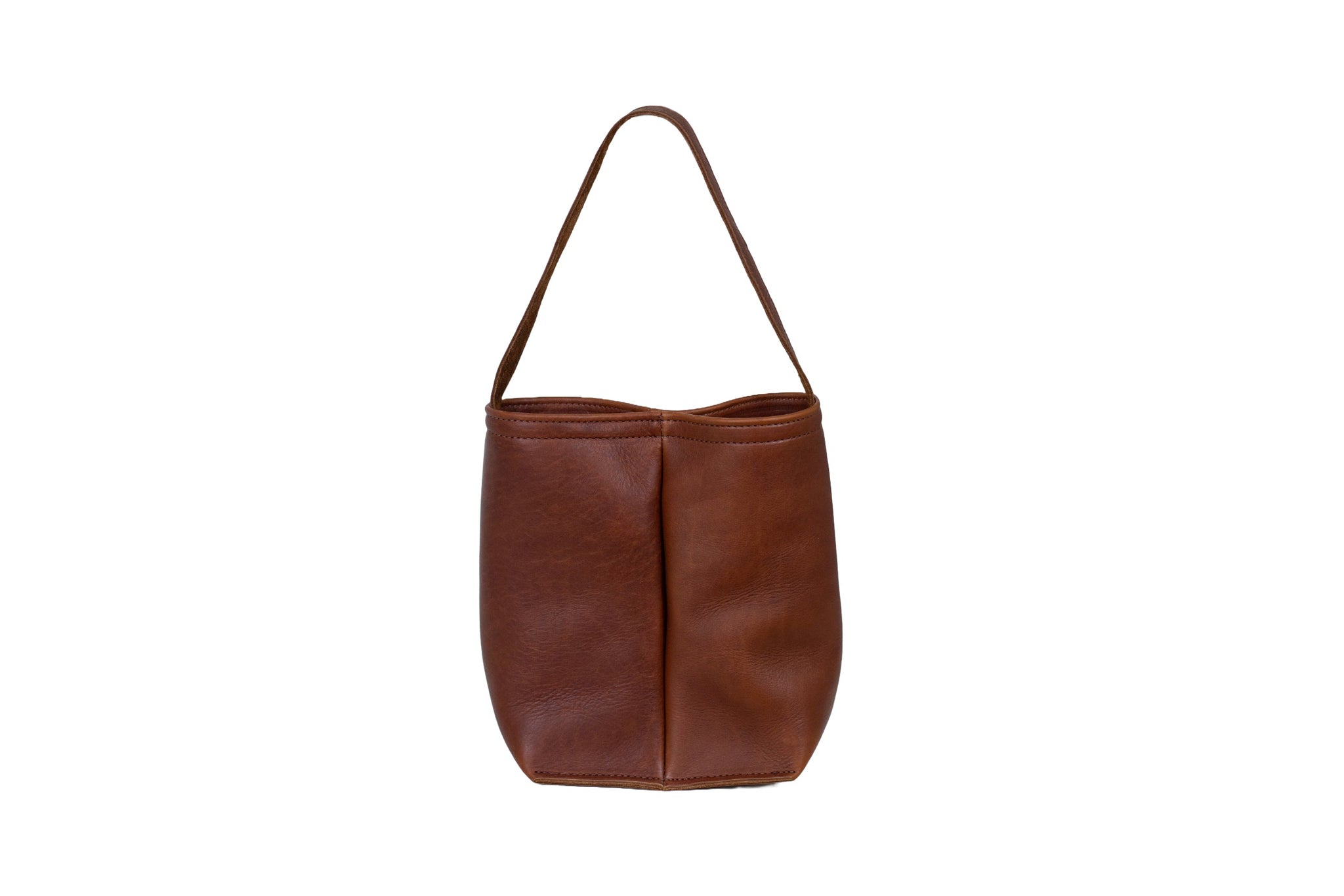 A brown leather bucket bag with a handle sits upright against a white background.
