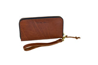 Urban Southern showcases its brown leather zip-around wristlet wallet with a wrist strap on a white background.

