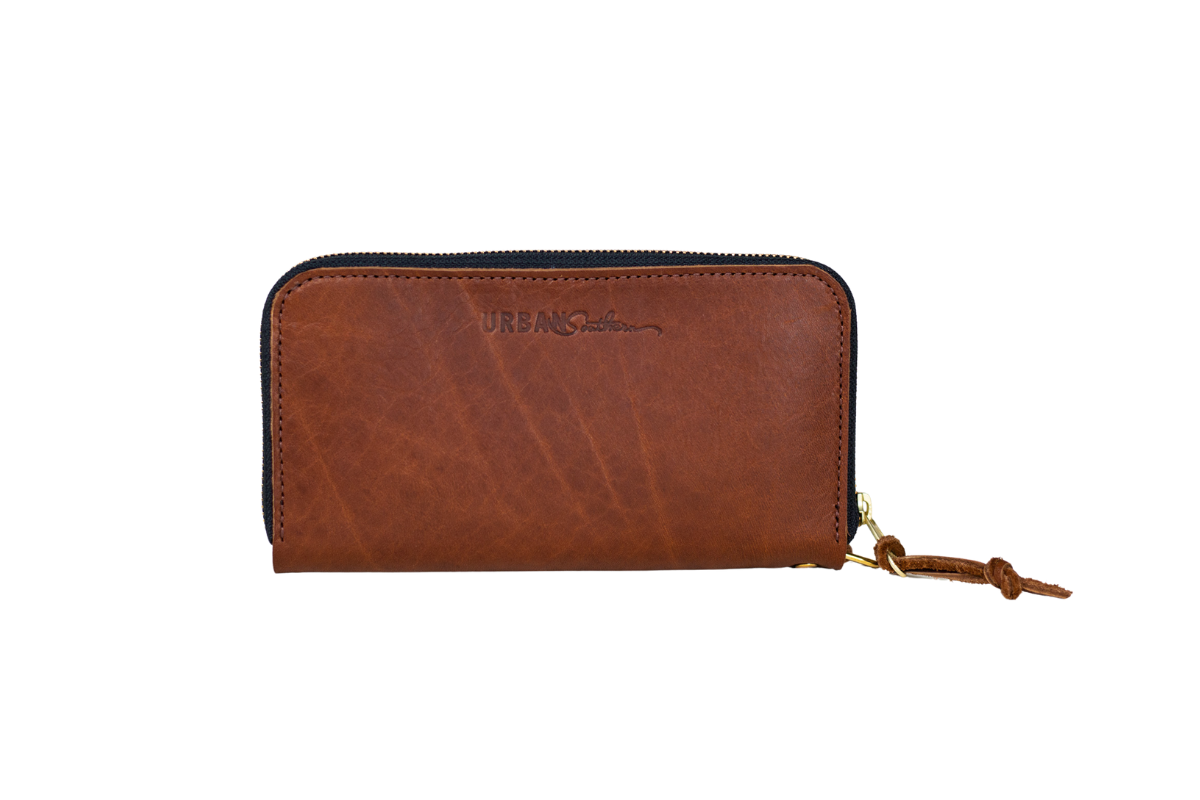 Urban Southern displays their brown leather zip-around wallet with a tassel pull.
