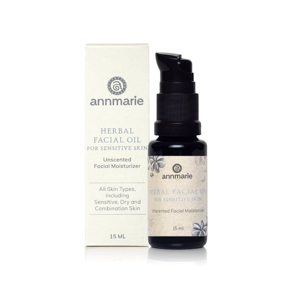Annmarie's unscented herbal facial oil for sensitive skin sits next to its packaging.
