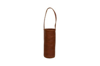 A brown leather wine tote bag stands upright with its carrying handle extended.
