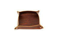 Showcases an Urban Southern leather valet tray with its logo stamped inside.
