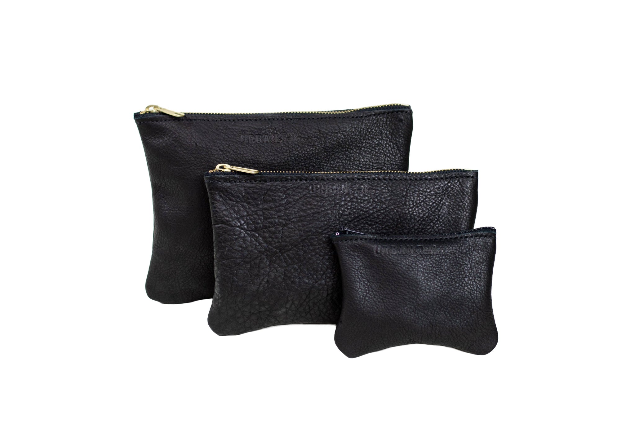 Three black leather zip pouches, in graduating sizes, display their textured material and gold zippers.
