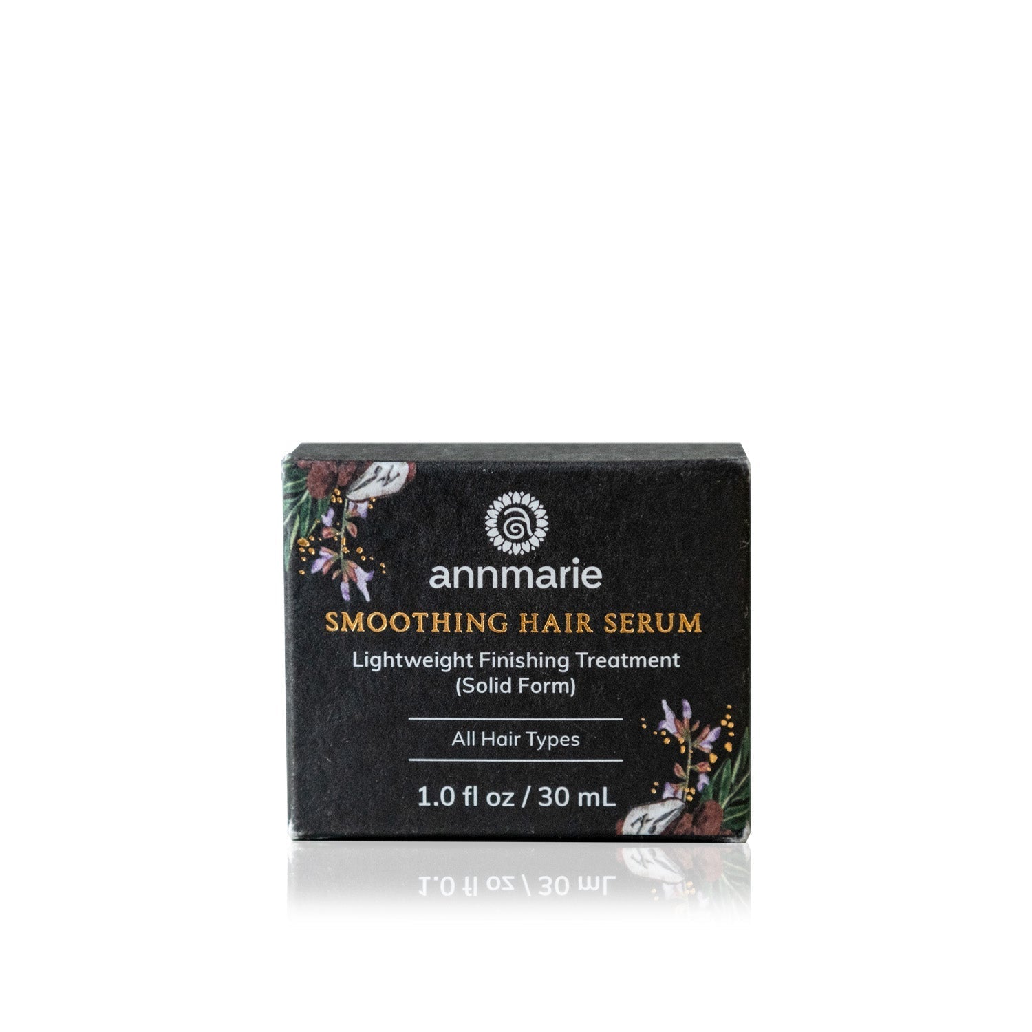 Annmarie smoothing hair serum, a lightweight finishing treatment in solid form for all hair types, sits on a reflective surface.
