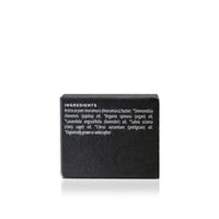 Close-up shows the ingredients list on a black container of organic skincare product, featuring murumuru butter, jojoba oil, argan oil, lavender oil, clary sage oil, and petitgrain oil.
