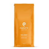 Purity Coffee advertises their "Balance" whole bean organic coffee blend in an orange bag.
