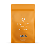 Purity Coffee displays its Balance blend of two-thirds decaffeinated, USDA Organic, Bird Friendly whole bean coffee in a bright orange bag.

