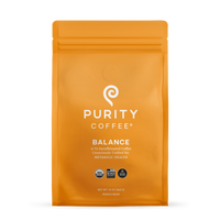 Purity Coffee displays its Balance blend of two-thirds decaffeinated, USDA Organic, Bird Friendly whole bean coffee in a bright orange bag.
