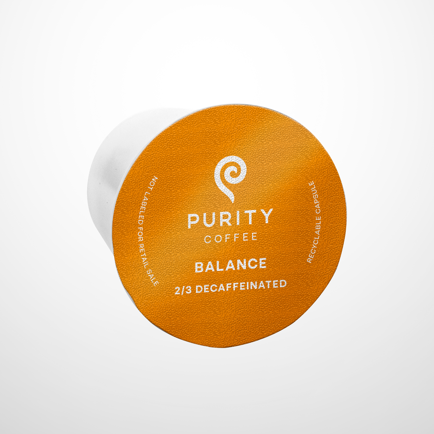 Purity Coffee displays its Balance blend 2/3 decaffeinated recyclable single-serve capsule.
