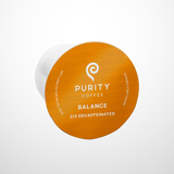Purity Coffee displays its Balance blend 2/3 decaffeinated recyclable single-serve capsule.
