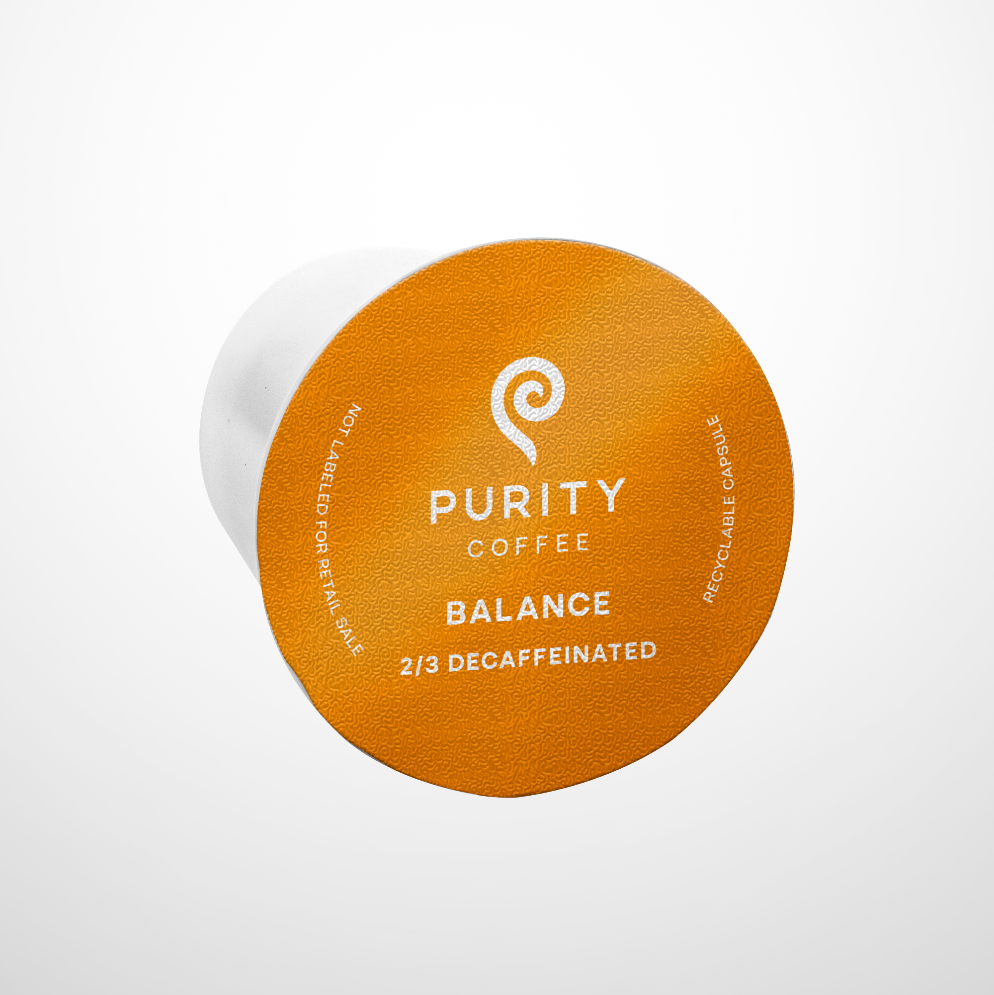 Purity Coffee displays its Balance blend 2/3 decaffeinated recyclable single-serve capsule.
