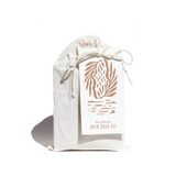 Showcases a URB Apothecary bath soak set packaged in a charming white drawstring bag, accentuated by a decorative botanical tag.
