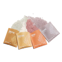Urb. Apothecary offers a variety of bath soak scents, including eucalyptus, cactus milk, rosehip, and lavender, shown in individual packets with corresponding colored bath salts.
