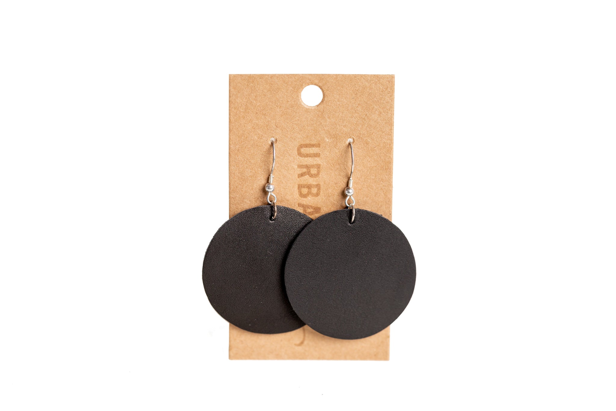Display presents chic, round black leather earrings hanging on a branded retail card.
