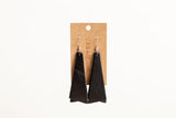 Showcases handcrafted Urban Southern black leather dangle earrings hanging on a branded display card.