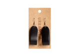 Urban Southern displays handmade black leather earrings on a branded cardboard earring card.
