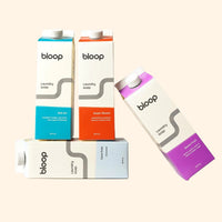 Bloop laundry soap offers a variety of scents, including Salt Air, Super Bloom, Care Free, and Stone Fruit, packaged in stylish carton containers.
