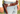 Person wearing a brown leather belt with a holster holding a gun, standing in a grassy field.