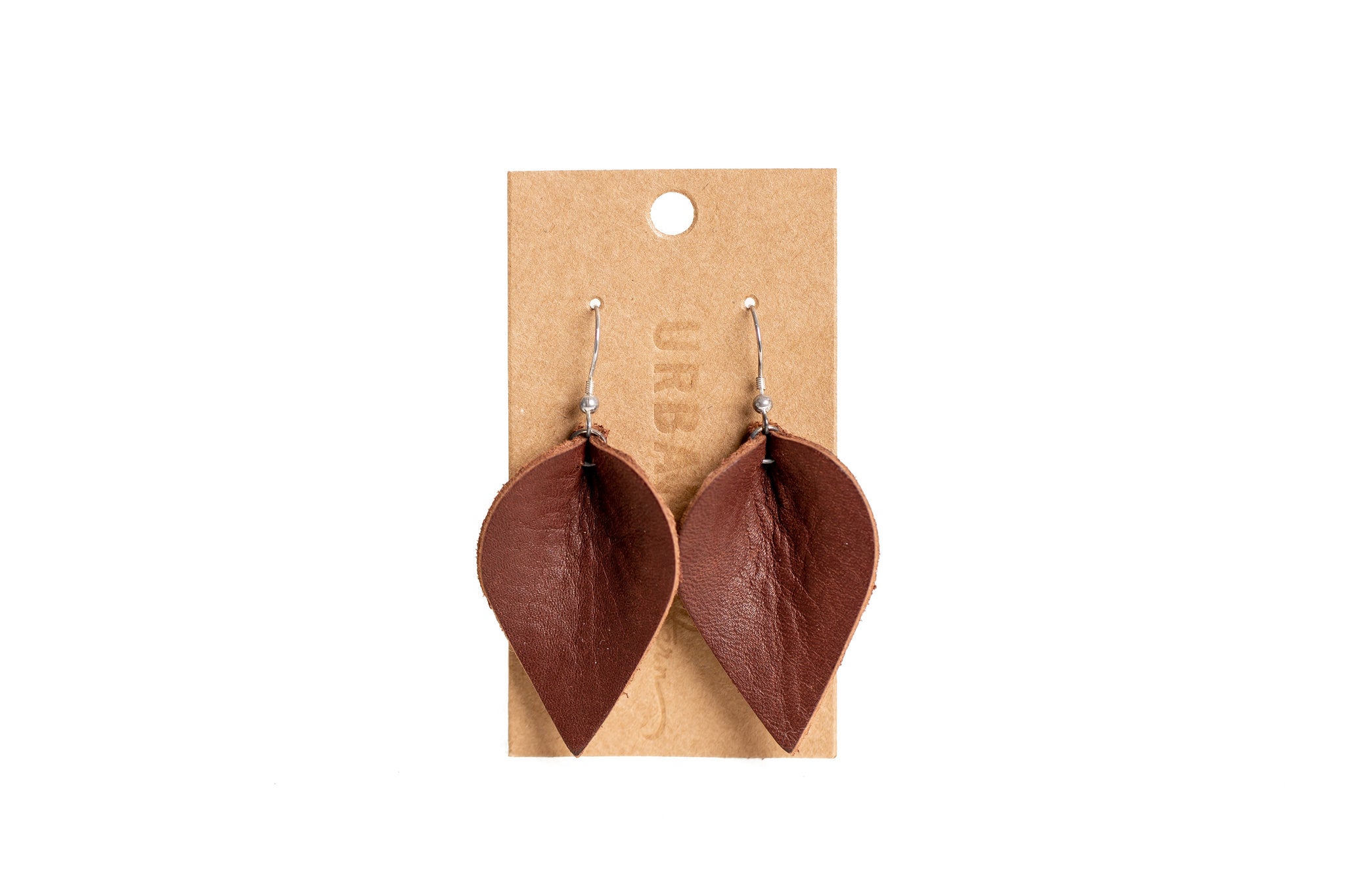 The image shows handcrafted brown leather leaf earrings hanging on a branded cardboard display card.

