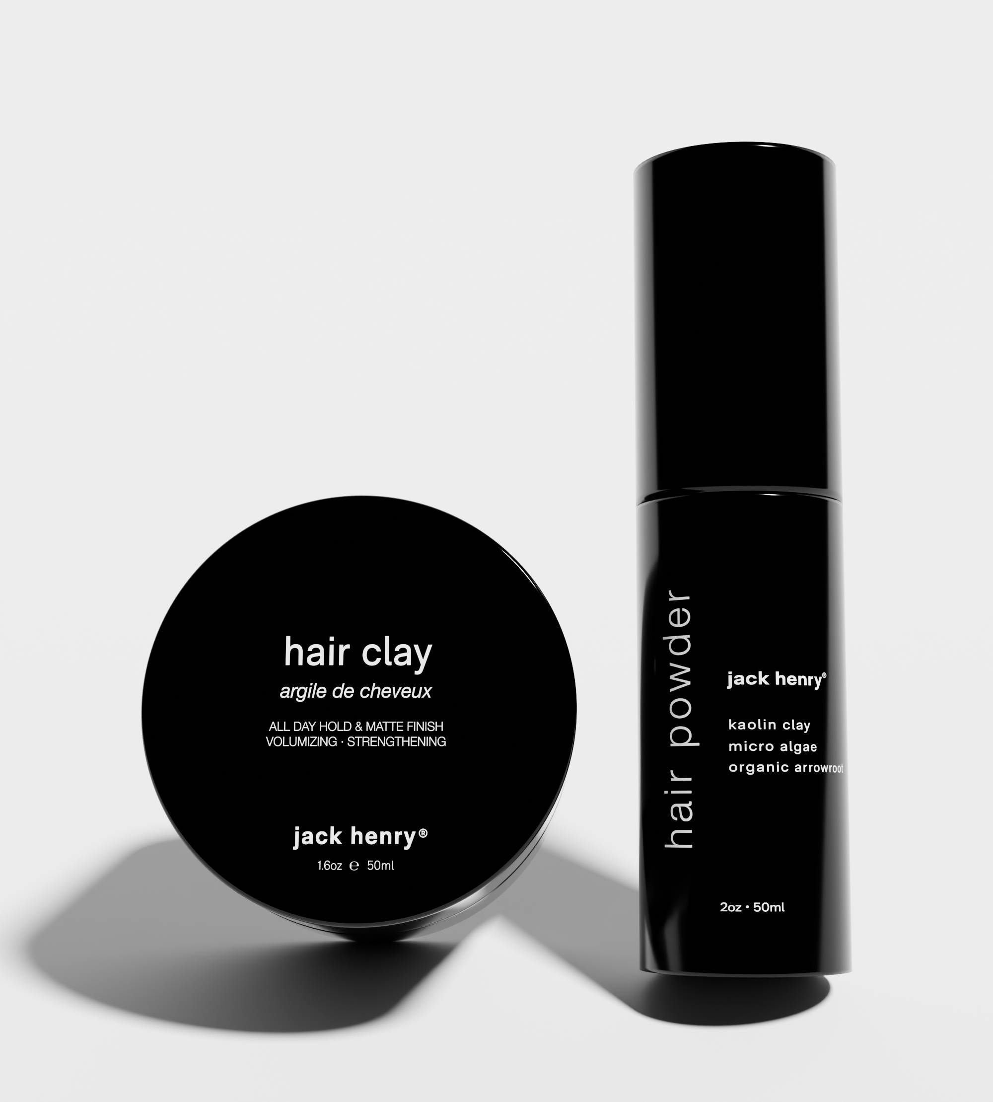 Displays Jack Henry hair clay and hair powder products, showcasing their minimalist black packaging.
