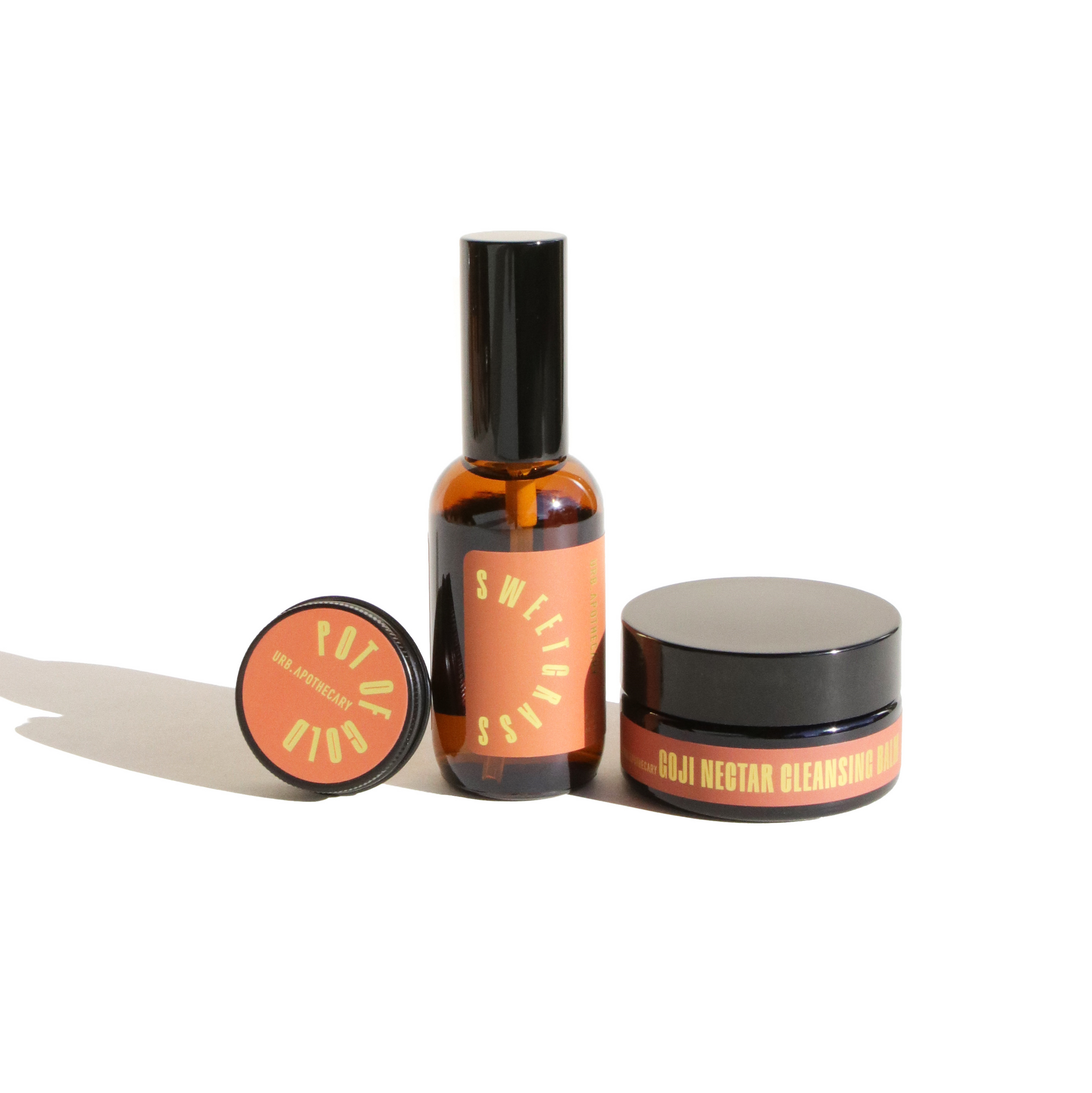 Showcases Urb Apothecary skincare products, including Sweetgrass serum, Goji Nectar Cleansing Balm, and Pot of Gold, on a bright white background.
