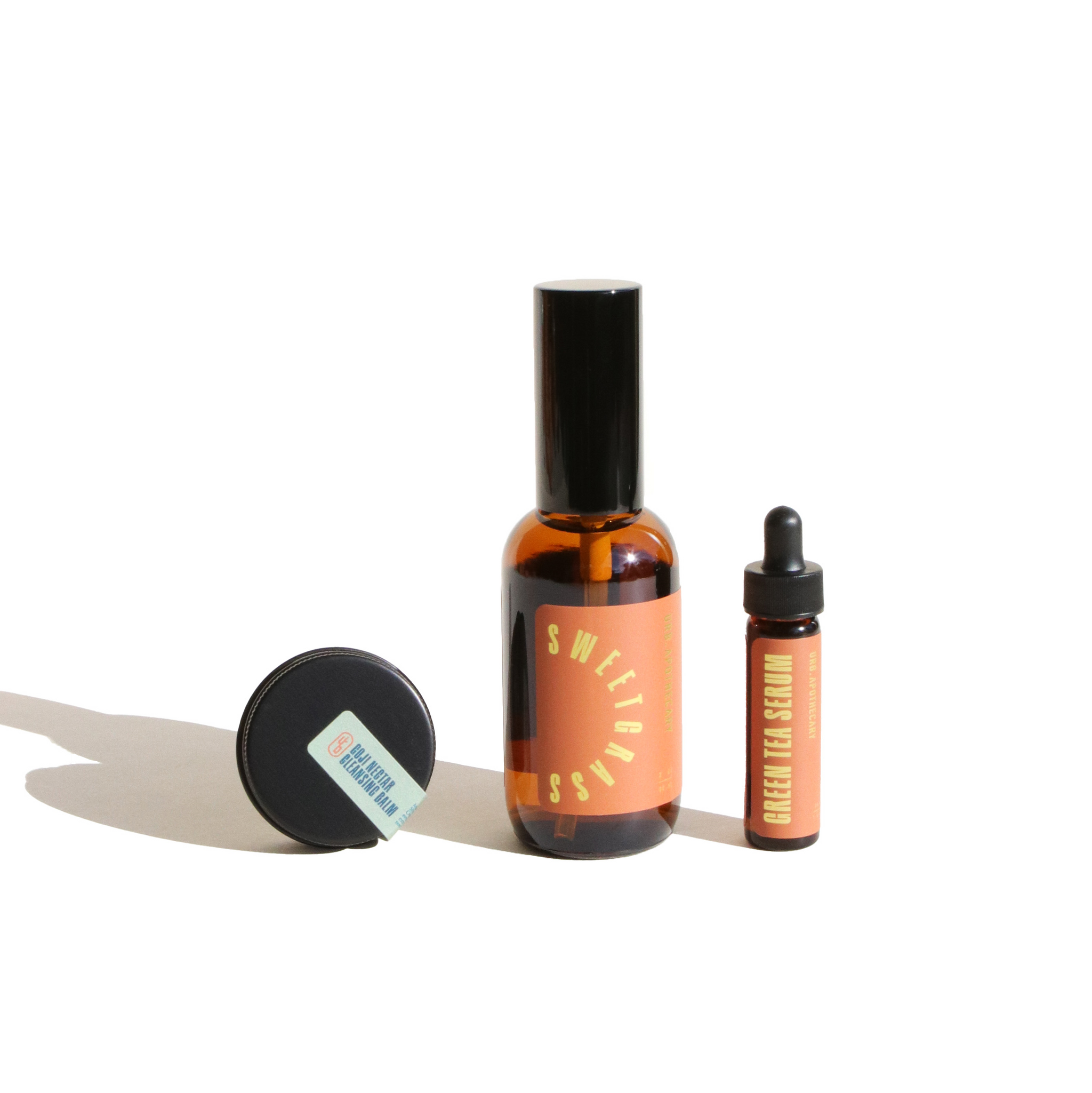 URB Apothecary features its Sweetgrass facial oil, Goji cleanser balm, and Green Tea serum displayed on a white background.
