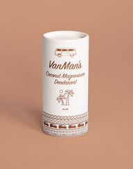 A white tube of VanMan's Coconut Magnesium Vanilla Deodorant displays camper van and palm tree illustrations against a tan background.
